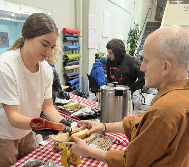 Hazel Nelson '25, serving hot dogs at the barbecue.
